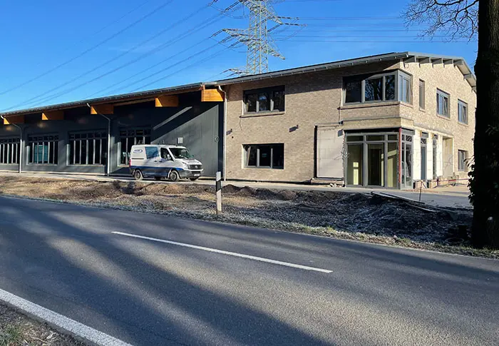 Middendorf-Bau GmbH: Ansicht eines neu gebauten oder renovierten Gebäudes mit Lieferwagen vor dem Gebäude.