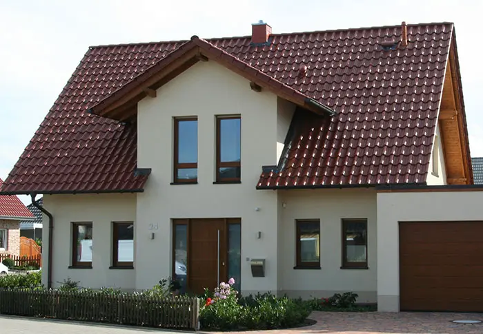 Referenz Hausbau: Ansicht eines modernen Einfamilienhauses mit Satteldach und Garage.