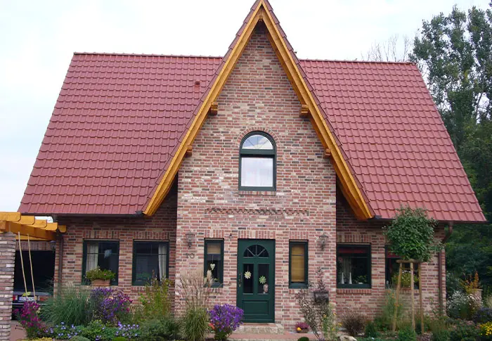 Ansicht eines Einfamilienhauses im Landhausstil mit rotem Ziegeldach und Fassade aus roten Backsteinen.