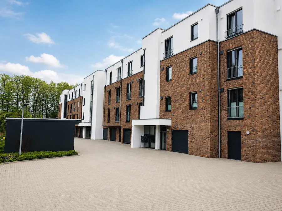 Modernes Kinderzentrum mit Holzfassade und gelbem Eingangsbereich vor blauem Himmel