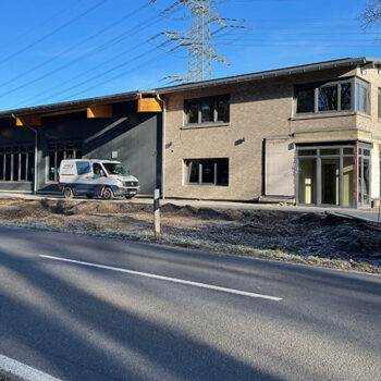 Middendorf-Bau GmbH: Ansicht eines neu gebauten oder renovierten Gebäudes mit Lieferwagen vor dem Gebäude.