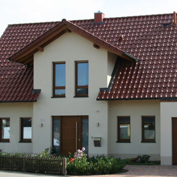Referenz Hausbau: Ansicht eines modernen Einfamilienhauses mit Satteldach und Garage.